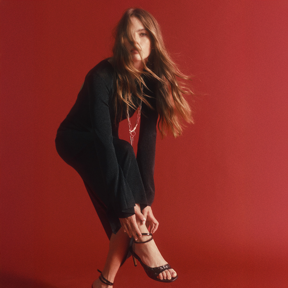 a brown-haired model wearing a black dress and black heels